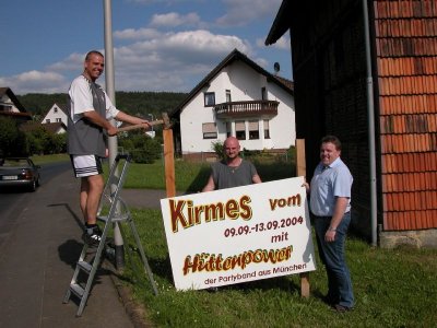 Kirmsvater Klaus Missing, Sven Langenegger und Erik Zinke beim Aufbau der Schilder, die die Kirmes ankündigen sollen